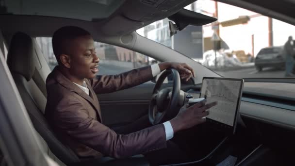 Portrait of a winner of African-American men.Happy african businessman celebrating success at luxury car.man turns on the radio in an electric car — Stock Video