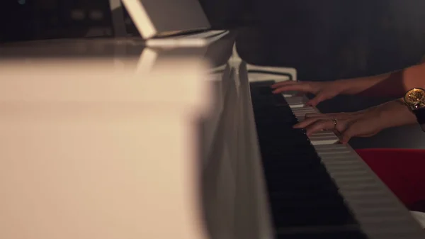 Nainen pianisti soittaa lempeää klassista musiikkia kauniilla flyygelillä lähikuvassa hidastettuna. Pianonäppäimet kiinni tummia värejä. Opiskelija kouluttaa soittamaan pianoa tekijänoikeusvapaita valokuvia kuvapankista