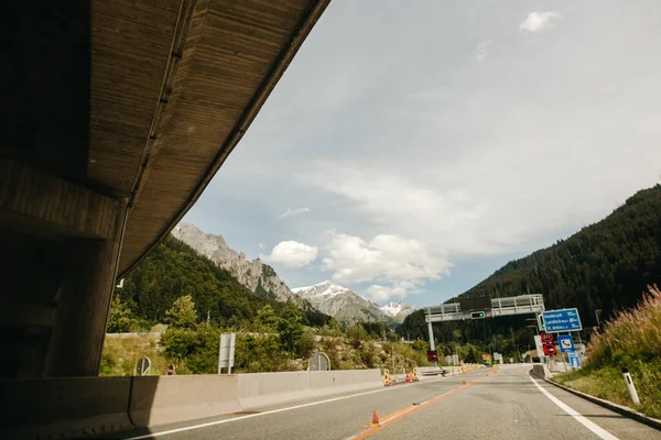 Alpský silniční les, hory a modrá obloha na pozadí v jasném slunečném dni. Dovolená na prázdniny. malebná rakouská krajina Alpská silnice, dálnice — Stock fotografie
