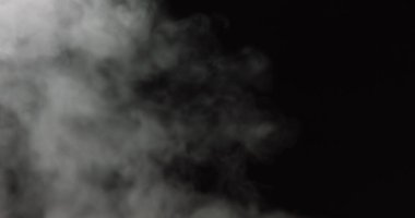 Atmosferik duman VFX kaplama elementi. Belirsiz bir geçmişi var. Siyah arka planda ağır çekimde duman. Beyaz duman, siyah arkaplana karşı uzayda yavaşça süzülüyor. Sis etkisi. Sis etkisi.
