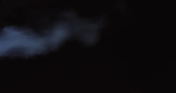 Atmospheric smoke 4K Fog effect. Smoke in slow motion on black background. White smoke slowly floating through space against black background