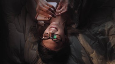 Sinsi internet sörfü. Akıllı telefondan sosyal ağda sörf yapan güzel hacker kız mesaj gönderiyor.