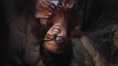 Sinsi internet sörfü. Akıllı telefondan sosyal ağda sörf yapan güzel hacker kız mesaj gönderiyor.