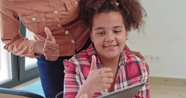 Niña adolescente afroamericana sonriente escuchando a la doctora pediatra consejera psicóloga escolar hablar con paciente adolescente en la consulta de terapia de chequeo, pediatra consultando adolescente negro — Vídeos de Stock