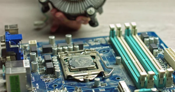 De tovenaar verwijdert CPU koeling voor diagnostiek. Reparatie en onderhoud van computerborden en de nieuwste processors. Vervanging van thermische spaanderpasta. In de moderne elektronische fabriek — Stockfoto