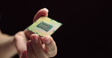 İşlemci bir teknisyenin elinde. İşlemci görünür arızalar için inceleniyor. Modern Elektronik İmalat Fabrikası Tasarım Mühendisi Mikroçipi 'nde. Yeni Nesil Mikroçipini Kapat