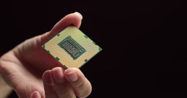 İşlemci bir teknisyenin elinde. İşlemci görünür arızalar için inceleniyor. Modern Elektronik İmalat Fabrikası Tasarım Mühendisi Mikroçipi 'nde. Yeni Nesil Mikroçipini Kapat