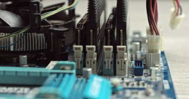 Kabloları bilgisayara bağlıyorum. Sistem ünitesinin içindeki bileşenler. Ana kartta video kartı ve RAM var. Dizüstü bilgisayardaki bir çipi bağlamak. Kablolarla bağlantı kur. Usta teknisyen bir bilgisayar monte eder