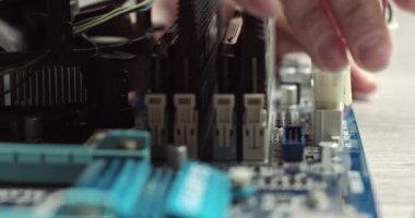 Kabloları bilgisayara bağlıyorum. Sistem ünitesinin içindeki bileşenler. Ana kartta video kartı ve RAM var. Dizüstü bilgisayardaki bir çipi bağlamak. Kablolarla bağlantı kur. Usta teknisyen bir bilgisayar monte eder