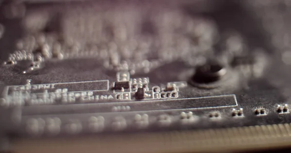 Câmera macro movendo-se lentamente sobre a placa de circuito impresso, mostrando componentes da placa-mãe do computador: transistores, resistências, capacitores, semicondutores. Dentro do Dispositivo Eletrônico. Cores vermelhas do néon — Fotografia de Stock