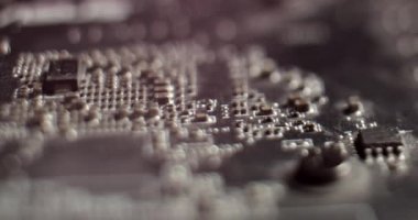 Makro Kamera, Bilgisayar Ana Kart Bileşenlerini, Transistörleri, Direnişçileri, Kapasitörleri, Yarı iletkenleri Göstererek Yavaşça Yazdırılmış Devre Tahtasından Geçiyor. Elektronik Cihazın içinde. Kırmızı Neon Renkleri