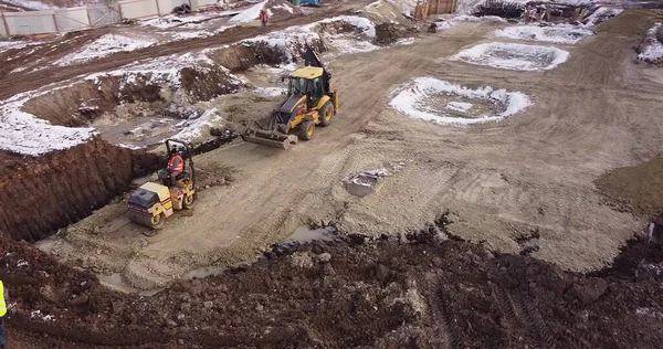 Aerial view of heavy machinery, tractor transporting land, construction preparation. The skating rink compacts the ground. Start of construction of the building flick. — Stock Photo, Image