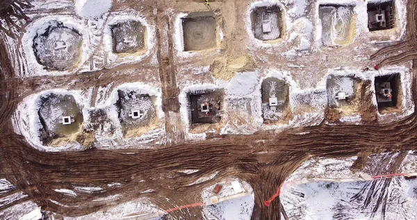 Bovenste opklimmende antenne uitzicht op een fundering van een framecentrum in de winter en werkende arbeiders. Sneeuwdag — Stockfoto