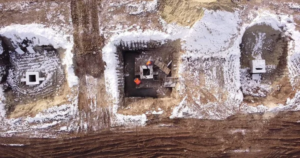 Bovenste opklimmende antenne uitzicht op een fundering van een framecentrum in de winter en werkende arbeiders. Sneeuwdag — Stockfoto