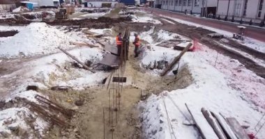 Mühendisler bir ev inşa ederken metal inşaatlarda çalışıyorlar. Yeni Yapılanma Geliştirme Alanında Hava Uçuşu. Güvenli Şapka Müteahhitlerinde Üst Aşağı Görünüm.