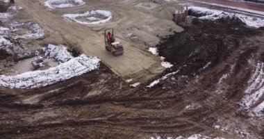 Ağır makinelerin ve inşaat işçilerinin elektrikli aletlerle çalıştığı yeni yapıların geliştirildiği bir alanın üzerinde havadan uçuş. Şehrin dışında endüstriyel tesislerin inşaatı.