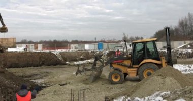 İnşaat alanında yükleyici kazıcı, buldozer ve paten işi. Makineler kazı işi yapar. Konut binaları için toprak ve moloz yığını. İnşaat işi