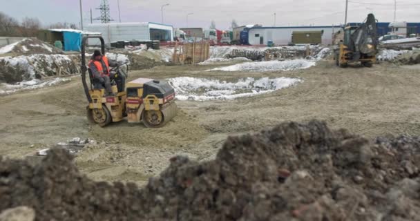 Trabajos de excavadora de cargadores, excavadora y rodillos en obra. Las máquinas realizan trabajos de excavación. Compactación de suelos y escombros para edificios residenciales. Trabajos de construcción — Vídeos de Stock