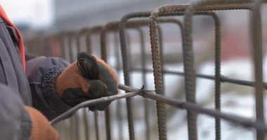 Mühendisler bir ev inşa ederken metal inşaatlarda çalışıyorlar. İnşaatın temelini güçlendirmek için takviye gücü kullanan işçilere yakın durun.
