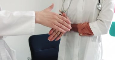 Hastanede tanınmayan doktorlar el sıkışıyorlar. Laboratuvar önlüklü iki tıp işçisinin el sıkışması. Takım çalışması, Ortaklık, Güven Konsepti. Farklı Milletler Doktorları