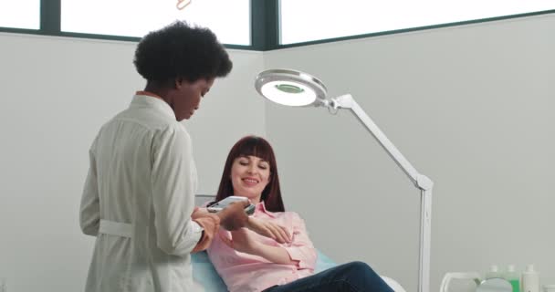 Médico profesional El dermatólogo investiga una marca de nacimiento en el teléfono conectado a la herramienta especial de dermatoscopia. Dermatólogo examina una piel. La dermatología verruga de la mano la piel humana se acercan — Vídeo de stock