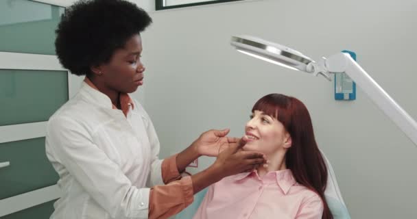 Plastic Cosmetic African Surgeon Examines Beautiful Womans Face, Touches it with Hands, Inspecting Healed Face After Plastic Surgery With Amazing Results. Consultation After The Operation — Stock Video