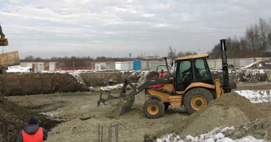 İnşaat alanında yükleyici kazıcı, buldozer ve paten işi. Makineler kazı işi yapar. Konut binaları için toprak ve moloz yığını. İnşaat işi