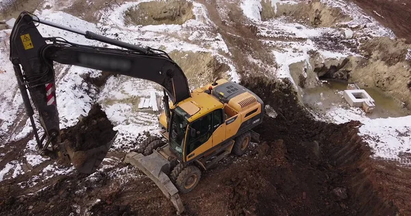 Aerial Flight Over a New Constructions Development Site разом з командою інженерів і архітекторів обговорюють проекти реального стану. Важкі машини й будівельники працюють на цій території. — стокове фото