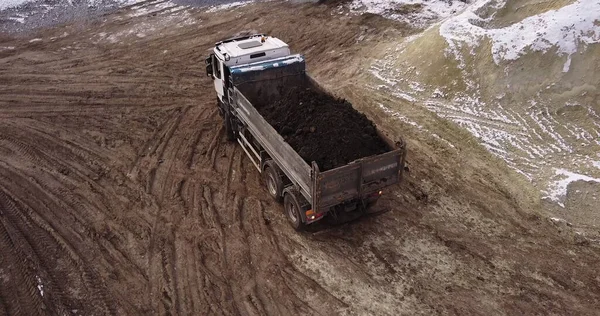 Dump truck Transports Soil On Construction Site. bovenaanzicht dump truck lossen bodem zand bouwplaats. grote bouwmachine die werkt — Stockfoto