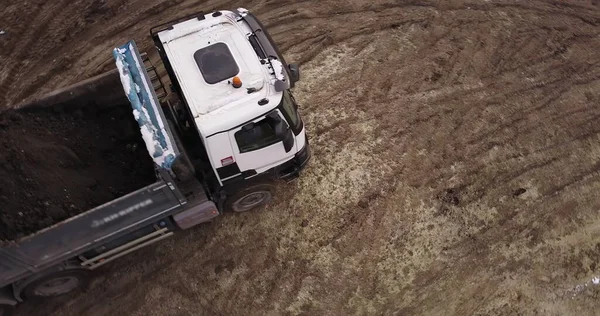 Dump truck Transports Soil On Construction Site. top view dump truck unloading soil sand construction site. big construction machine working — Stock Photo, Image