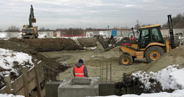 Lastare grävmaskin, bulldozer och rullarbete på byggarbetsplatsen. Maskiner utför schaktningsarbeten. Komprimering av jord och spillror för bostadshus. Anläggningsarbeten — Stockfoto