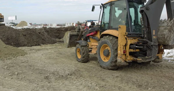 Mașini de construcții la lucru la construirea unei case. Diferite tipuri de tractoare și excavatoare pregătesc solul pentru construcția plantelor în zona industrială. Buldozer Rides on Sandy Road — Fotografie, imagine de stoc