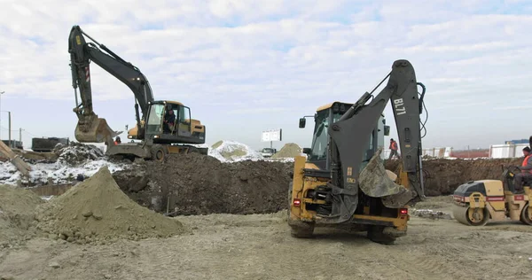 Byggmaskiner i arbete på byggnad ett hus. Olika typer av traktorer och grävmaskiner Förbered marken för anläggningskonstruktion i industrizonen. Bulldozer Rides på Sandy Road — Stockfoto