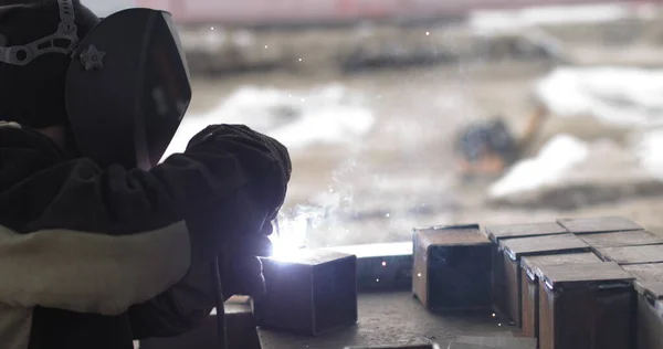 Kovový svářeč pracující se svařovacím strojem s jasnými jiskry a záblesky Konstrukce svaru Kovová konstrukce Na venkovním staveništi — Stock fotografie
