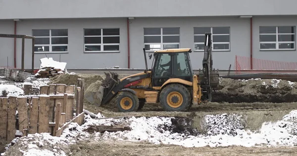 A buldózer homokos építkezésen dolgozik, oldalnézetből. Új Big Tractor, egy buldózer kerekeken egy homokos úton egy építési területen szinten a helyszínen az építési ingatlan — Stock Fotó