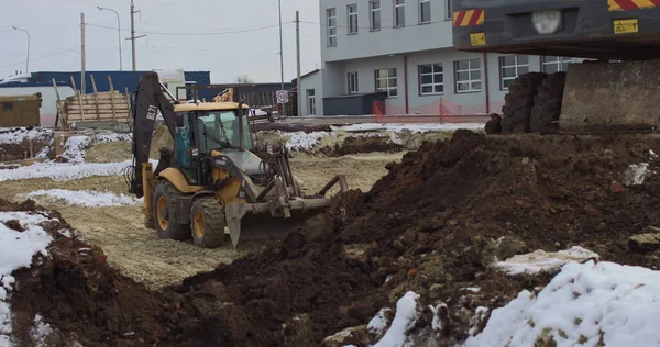 Bulldozern arbetar på en byggarbetsplats med sand, sidovy. Ny stor traktor, en bulldozer på hjul på en sandig väg på en byggarbetsplats nivåer platsen för byggandet av fastigheter — Stockfoto
