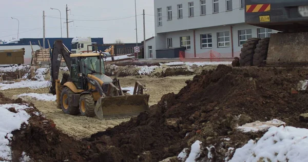 A buldózer homokos építkezésen dolgozik, oldalnézetből. Új Big Tractor, egy buldózer kerekeken egy homokos úton egy építési területen szinten a helyszínen az építési ingatlan — Stock Fotó