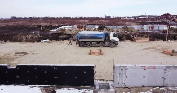 Вантажівка пересувалася з брудом і грунтом на ділянці дорожньо-будівельного комплексу. Вивантаження грунту або піску на будівельному майданчику — стокове фото