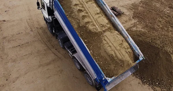 Camião basculante descarregando solo ou areia no canteiro de obras — Fotografia de Stock