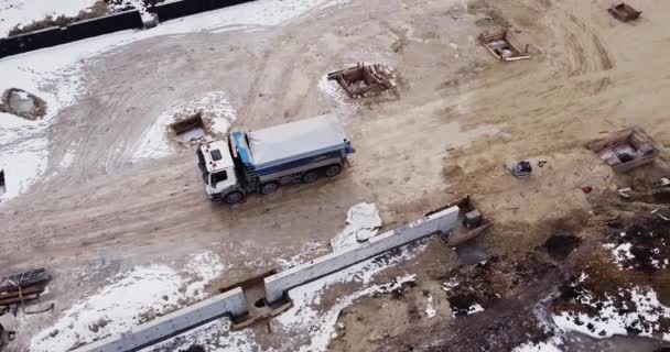 Vista aérea de maquinaria pesada, camión articulado moviendo suciedad en un nuevo sitio de construcción de carreteras, equipo pesado arriba hacia abajo material de archivo de camión volquete — Vídeo de stock