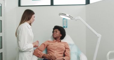 Randevu saatinde danışmanlık bölümünden bir doktorla konuş. Klinikteki hasta danışmanlığı. Genç, güzel, beyaz bir kız. Doktor, Afrikalı bir Amerikalıyla konuşuyor. Hastaneye giriş.