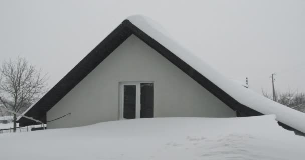 Telhado de casa congelado no inverno, quando há queda de neve com flocos de neve - temperaturas geladas na temporada de Natal. Telhado coberto de neve com nuvens brancas e bokeh Close Up Slow Motion — Vídeo de Stock