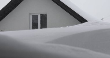 Kışın, kar taneleri ve Noel mevsiminde dondurucu sıcaklıklarda donmuş bir evin çatısı. Beyaz bulutlu karla kaplı çatı ve bokeh - Yavaş Hareketi Kapat