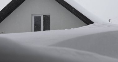 Kışın, kar taneleri ve Noel mevsiminde dondurucu sıcaklıklarda donmuş bir evin çatısı. Beyaz bulutlu karla kaplı çatı ve bokeh - Yavaş Hareketi Kapat