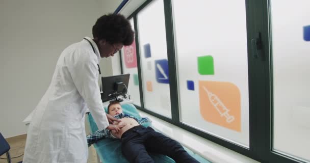 Egy 12 éves gyerek kórházban van. A Doktor megvizsgálja a Gyermek Hasi Fájdalmat. Orvosszakértő az egészségügyi ellátás nyújtásában Konzultáció Vizsgálat a kórházban — Stock videók