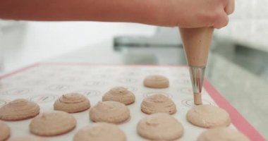 Şef, Macaron Tatlısını Hazırlamak için Üs Yapıyor. Makarna tatlısı pişirmek için metal tepsinin üzerine boru torbası konan kas kreminin yakın çekimi. Pişirme, Pişirme kavramı