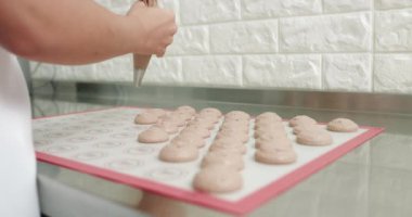 Kahverengi makarna yapıyorum. Kahverengi makarna karışımı sırt çantasının üstünde, şefin profesyonel elleri boru torbasıyla makarna yapıyor. İç Görüntü - Yatay Görüntü