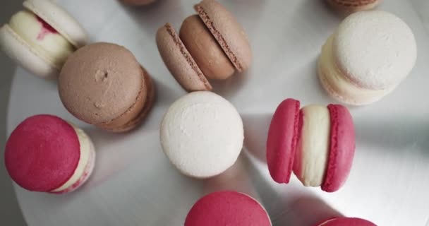 Close up of colorful white, red, and caramel chocolate macarons dessert, filling with tasty ganache, on the table at light kitchen or confectionery shop. Colorful Macarons Colorful Pastel Macarons — Stock Video