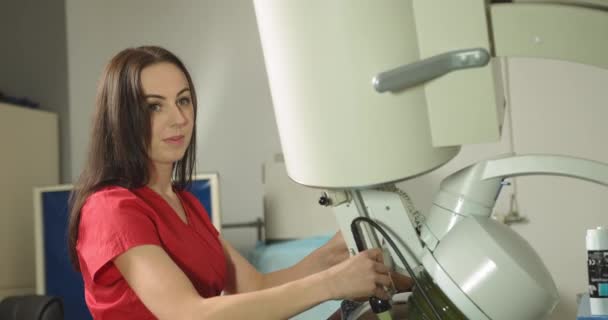 Procedimiento de litotricia extracorpórea por ondas de choque en el moderno centro médico de urología. Primer plano de la mujer caucásica bonita médico que proporciona tratamiento de piedra para el paciente varón negro usando litotripter — Vídeo de stock