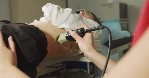 Terapia extracorporea delle onde d'urto in urologia. Colpo ritagliato di paziente donna sdraiata, con ultrasuoni per determinare la posizione dei calcoli renali prima della procedura di litotripsia. — Video Stock